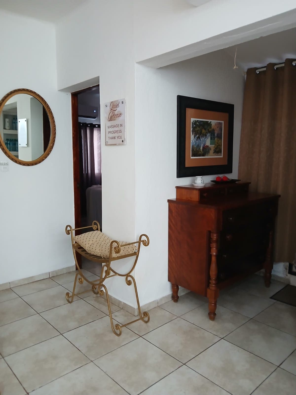 Quiet hallway with gold benches and a round mirror