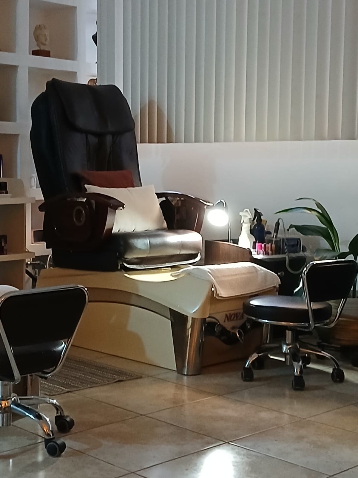 Pedicure station with a massaging chair, foot basin and folded towels