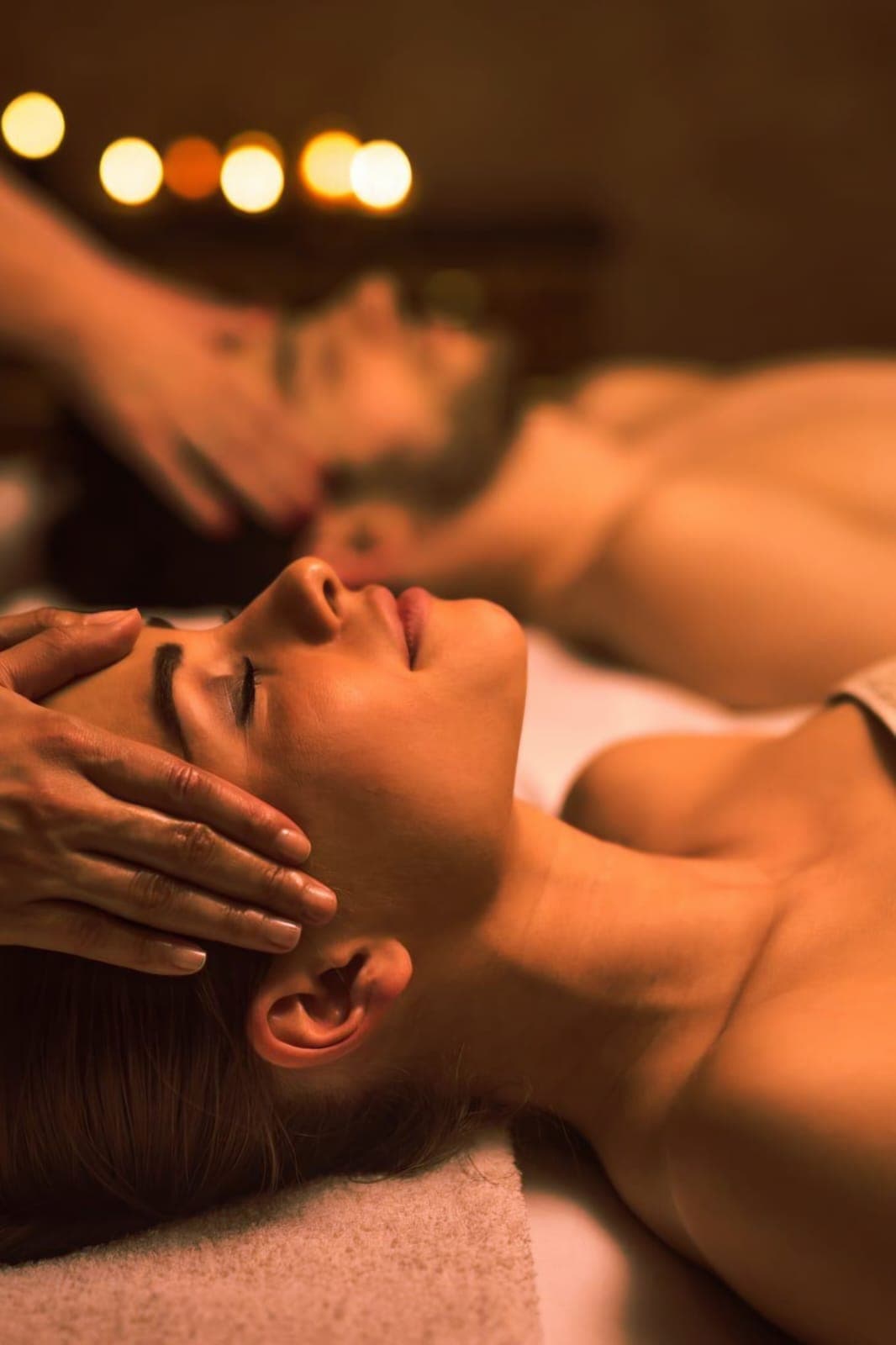 Guest relaxing during a head massage in warm light